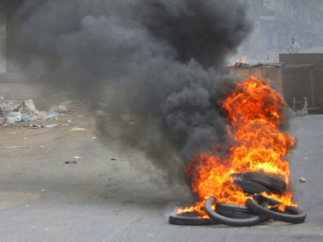 Karachi Violence, man rides a motorcycle