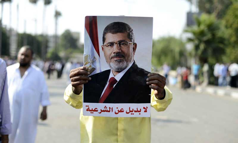 A supporter of Mohamed Morsi holds a picture of him during a rally outside Cairo University. — Photo by AFP