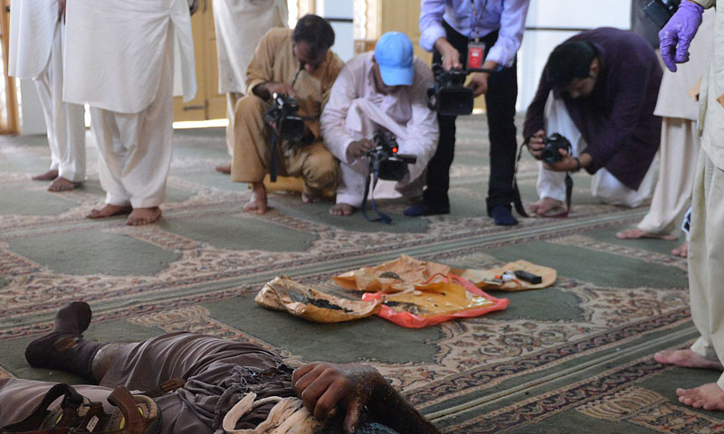 Television cameramen record footage of explosives and the body of the suicide bomber inside the mosque on the outskirts of Islamabad on August 9, 2013.—AFP Photo